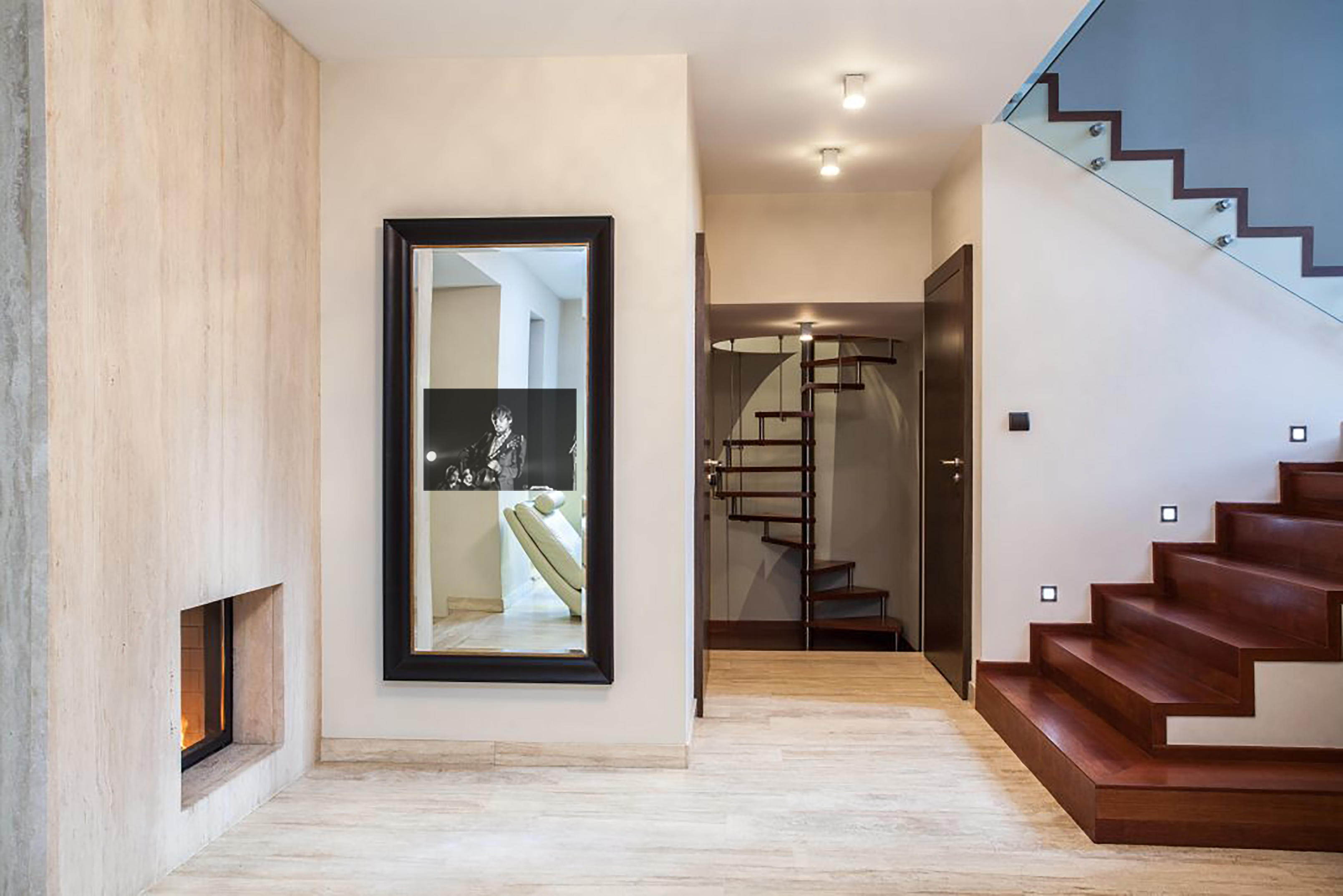turned on reflectel mirror tv on a wall at the bottom of staircase