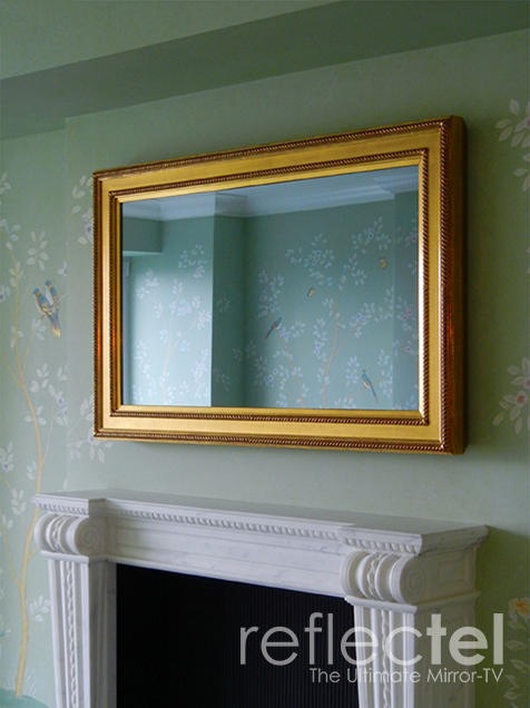 Gold Carved Frame Portolio Reflectel Mirror Tv Hangs Over Carved White Wooden Mantle On A Green Floral Wall