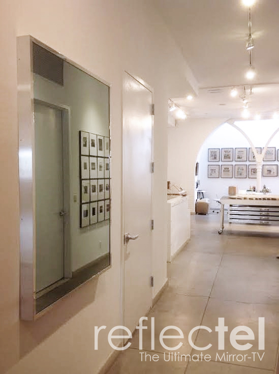silver metal reflectel mirror tv hangs on wall Portfolio