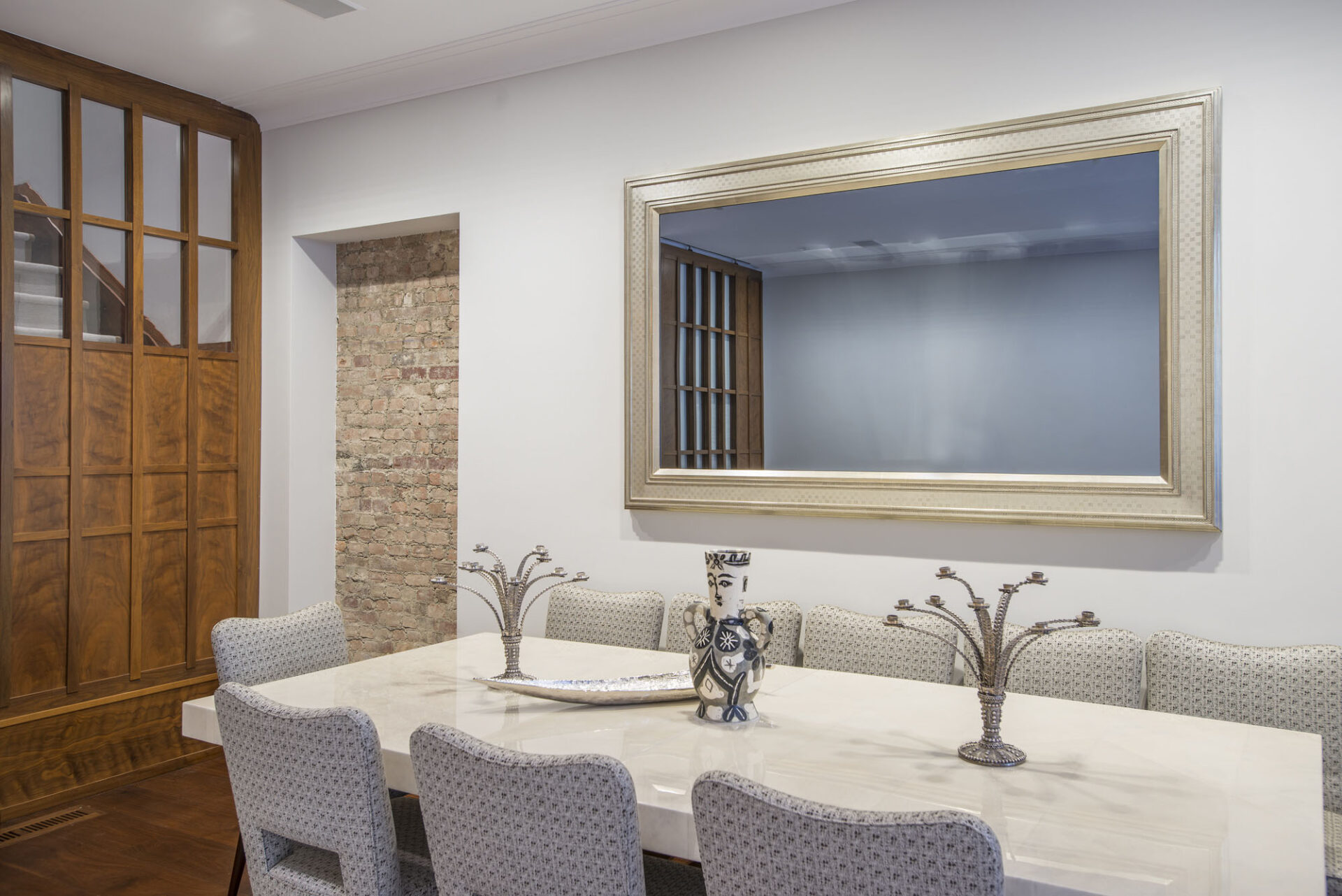 gold gilded reflectel mirror tv turned off hangs on the wall over dining room table