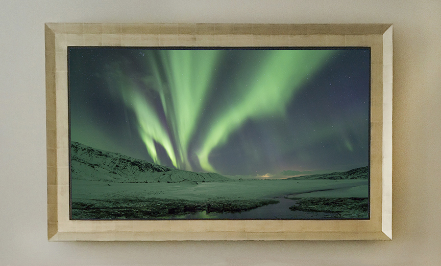 Gold Mirror TV gold reflectel mirror tv hangs on wall with screen showing northern lights