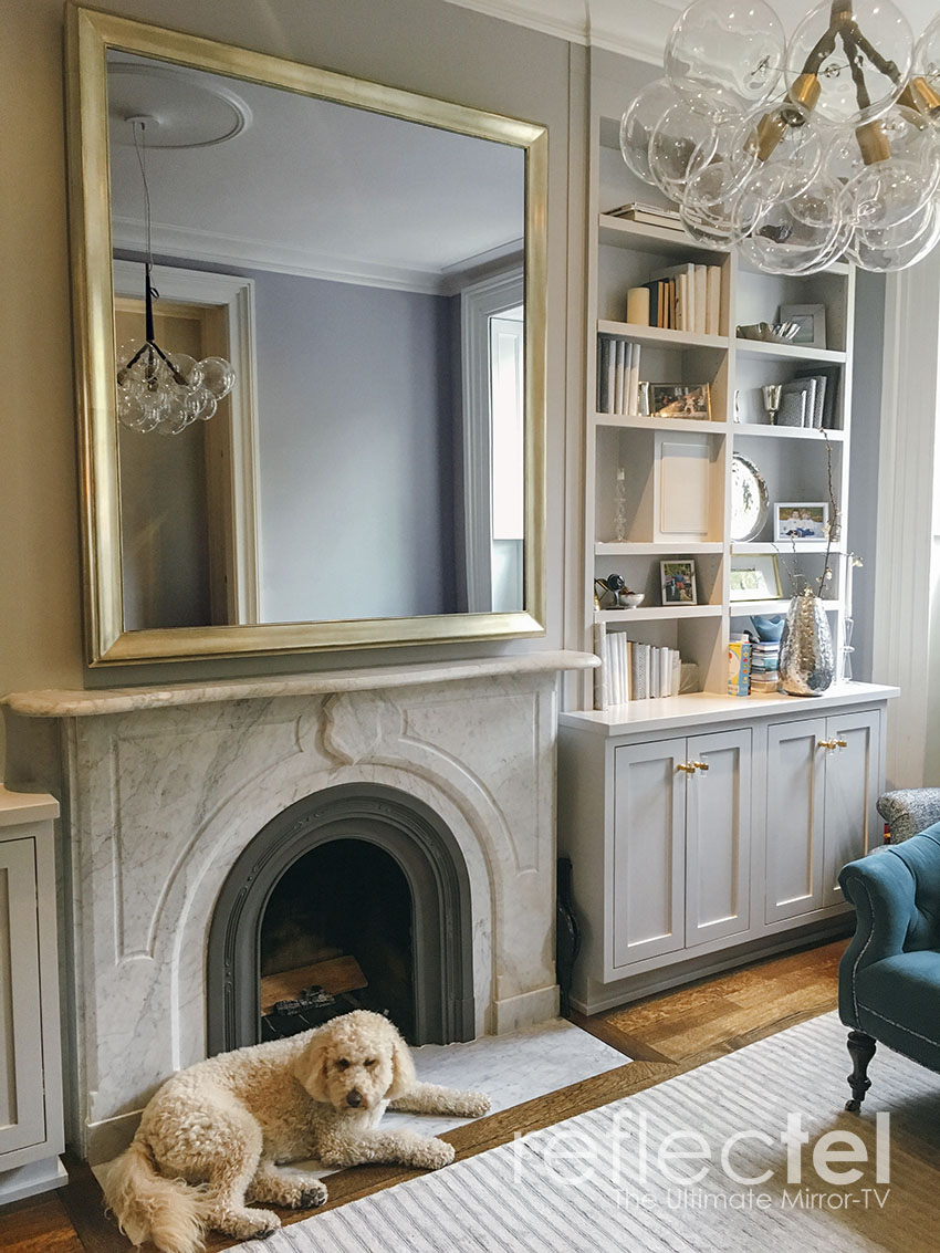 gold Portolio refectel mirror tv hangs over marble mantle in nyc apartment