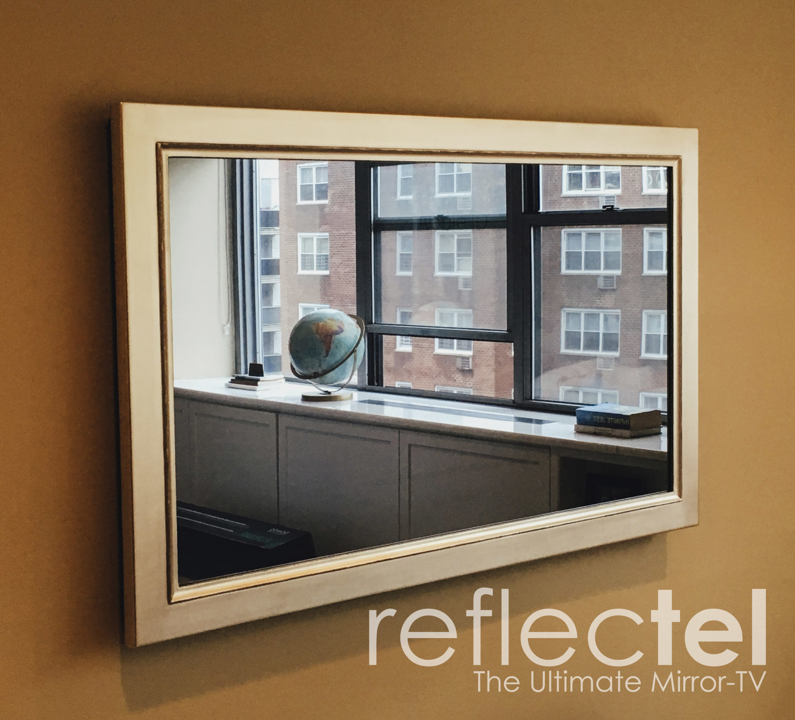 Gilded shaped mirror television job in NYC living room globe in reflection