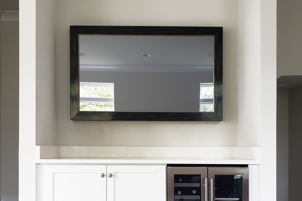 Turned Off Mirror Tv With Black Wood Grain Frame Above Kitchen Counter