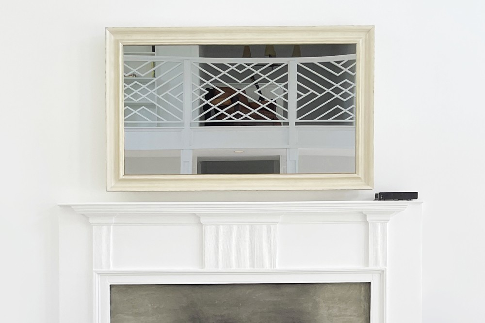 Tv Mirror With A White Cream Frame Over A Mantel Fireplace