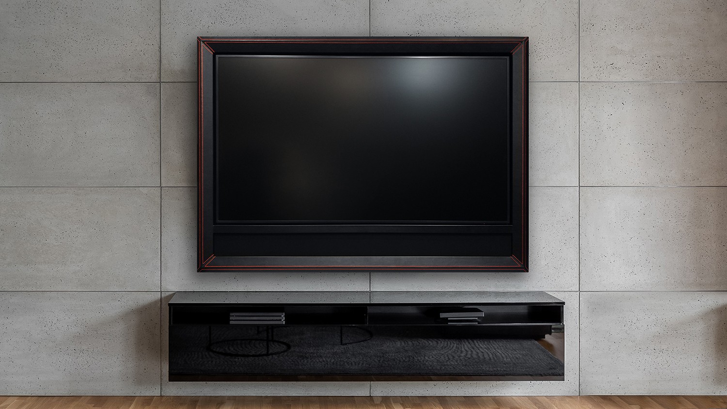 Framed TV With A Black Leather Frame And Red Stitching And A Soundbar