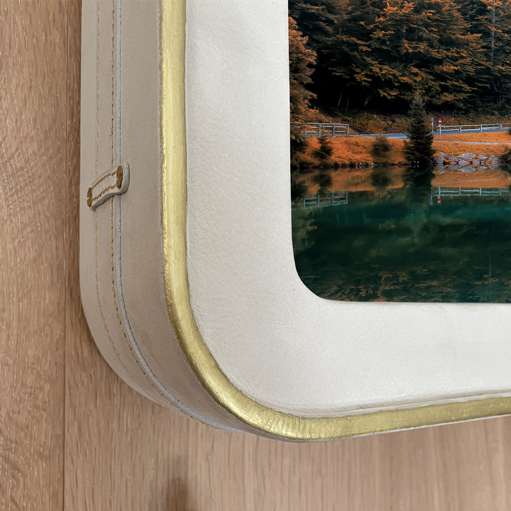 Closeup Image Of A TV Frame In White Leather With Gold Trim Round Shape