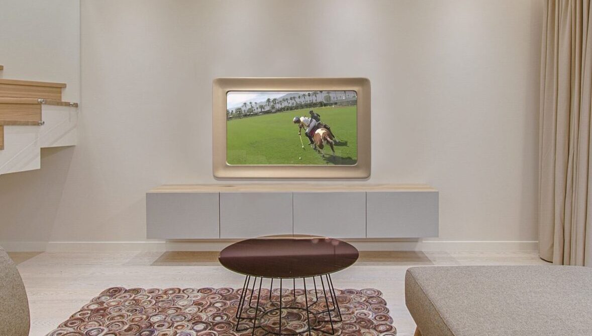 swoop sculptural framed tv in mirror in living room