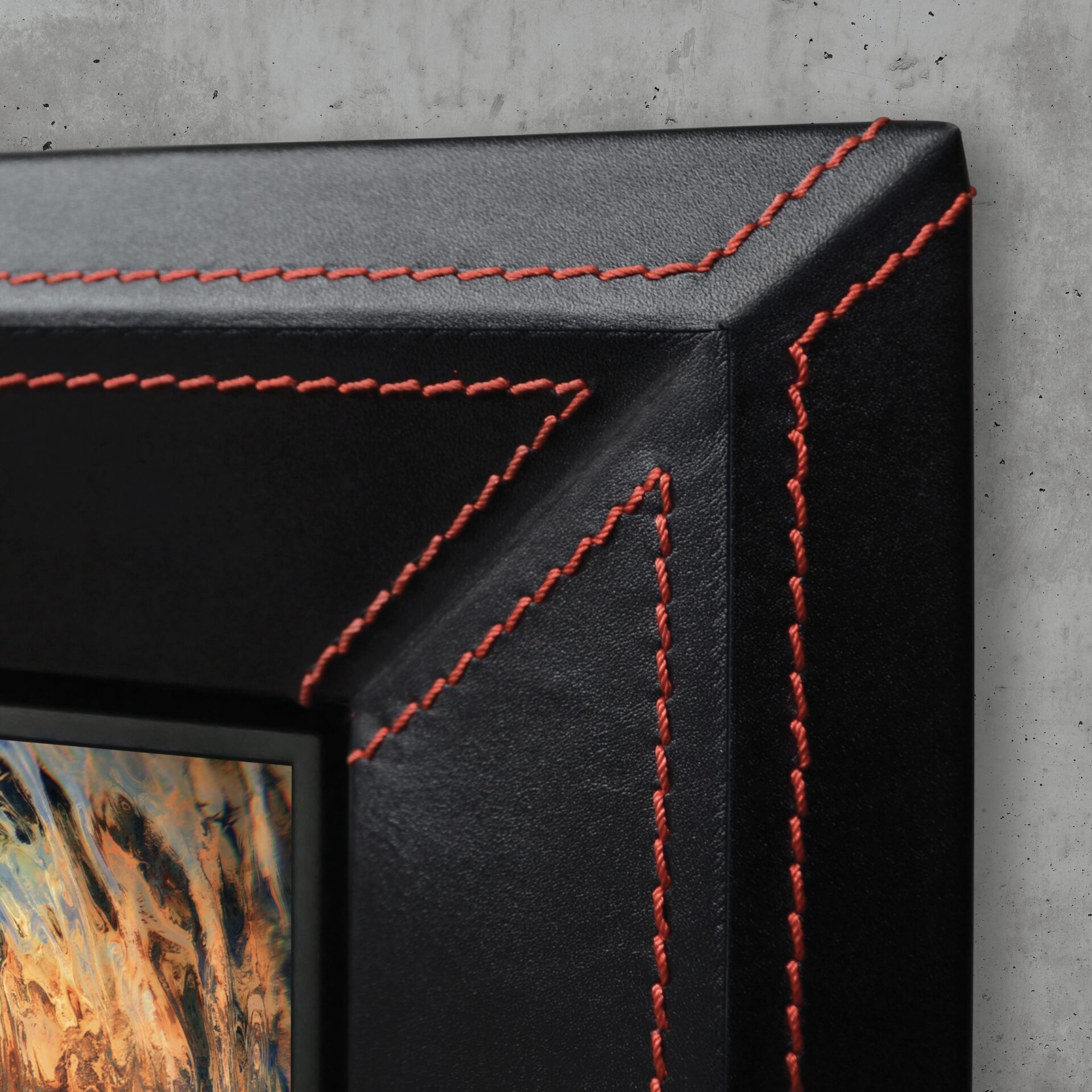 Closeup Of Black Leather Tv Frame With Red Stitching Hidden Tv On