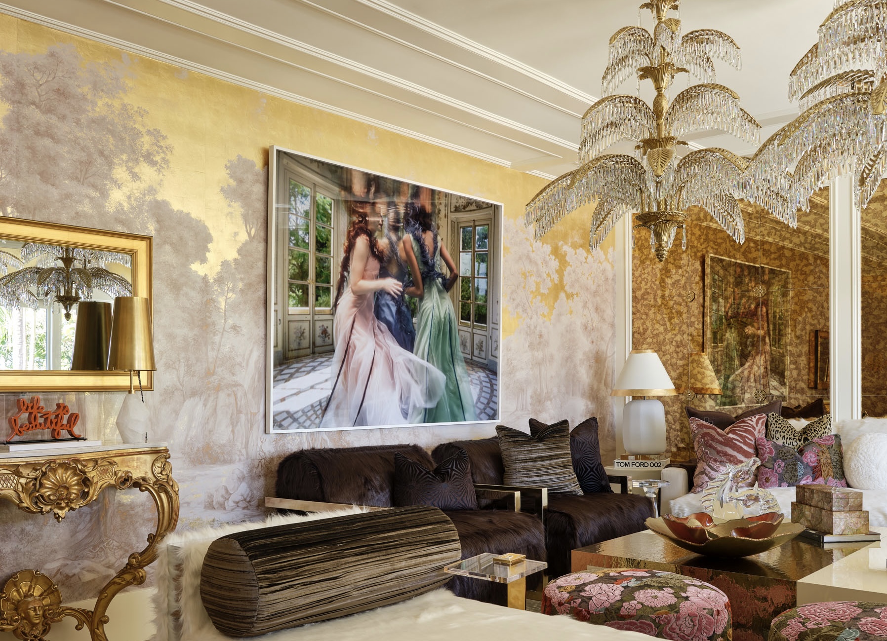 kips bay show house palm beach 2026 lori morris design gilded palm room with gold framed hidden tv mirror, artwork on the walls, luxury seating, palm tree chandeliers, gold painted walls, luxury high end design