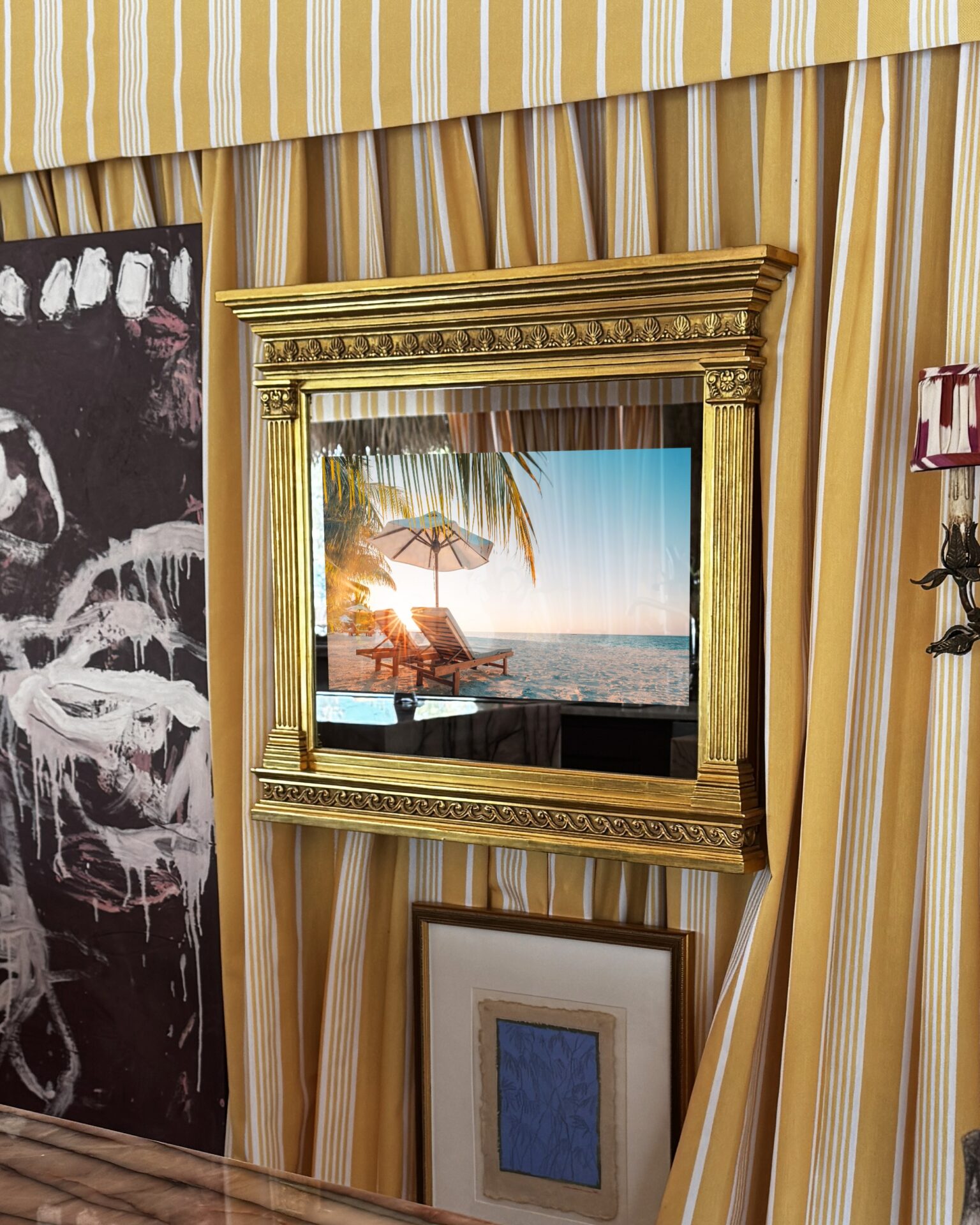 tv on mirror in gold carved frame hiding the tv in kips bay show house palm beach tiki tent with yellow striped schumacher curtains and gallery wall with hidden tv on