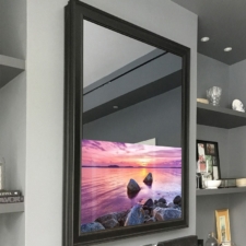 43" Portrait - Signature Shaped 43 inch television in a portrait orientation with black sleek frame over mantel fireplace by famous interior designer
