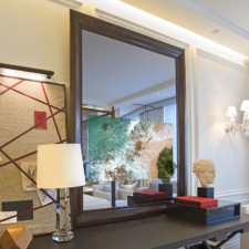 49" Portrait Plus - Specialty Wood Framed hidden TV in a portrait-oriented mirror mounted atop matching dark wood desk in Baccarat Hotel suite.