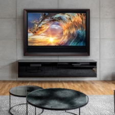 65" Floater TV Frame - Leather with Ferrari-inspired stitching Modern living room with a TV hidden in a mirror, framed in black, above a sleek matching console.
