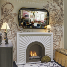 55" Ellipse Contour - Leather in HearthCabinet Ventless Fireplaces BDNY 2025 Javitz Centerbooth - Photo credit: Menti Studio Mirror TV over fireplace mantel at BDNY tradeshow with round leather frame