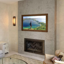 55" Landscape - Zirconia Bronze Metal w/ painted wood liner bronze metal Mirror TV over a modern fireplace in living room