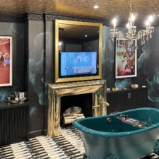 43" Portrait Plus - Signature Shapes: Kips Bay 2024 Gold Framed TV in Mirror over gold fireplace mantel with green tub in center of room