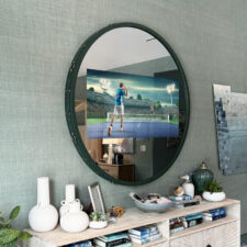 50" Circle - Leather - Elissa Grayer/Holiday House Hamptons 2024 round circle mirror tv with green edelman leather over a credenza in hamptons bedroom