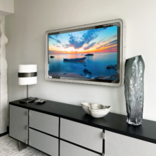55" Rounded Corner Leather Mirror TV with a rounded leather frame over a black and white dresser