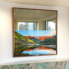 65" Square Plus - Copper Leather Square Mirror TV with a thin copper leather frame over colorful fireplace