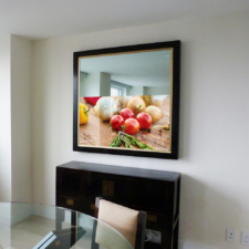 Dark wood framed mirror tv with gold liner in dining room