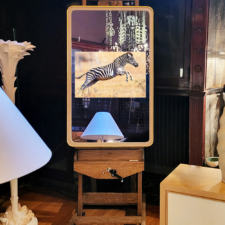 55" Rounded Corner installed vertically - Leather Framed mirror tv with rounded corners displaying image of zebra while resting on easel.