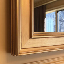 Signature Shaped - SS9-G-O Warm gold prefinished frame around a Reflectel Mirror TV corner.