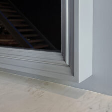 Specialty Wood in custom Benjamin Moore paint Layered light gray frame around Reflectel television turned off on light gray wall.