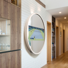 55" Circle - White Leather Circle mirror TV with white leather frame turned on to tennis match