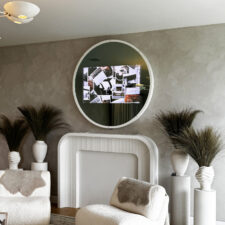50" Circle - White Leather with stud details: Holiday House Hamptons 2025 White leather framed circular mirror television with white button details turned on in grey modern living room