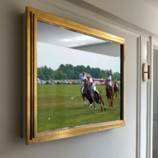55" Landscape Plus - Gilded Shaped Side view of mirror television with gold gilded frame turned on displaying a polo match.